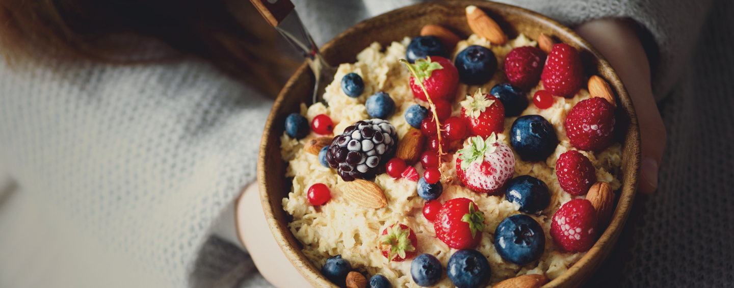 Eine Holzschüssel mit Haferbrei, Mandeln und Beeren